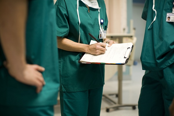 Three surgeons in operating room, mid section